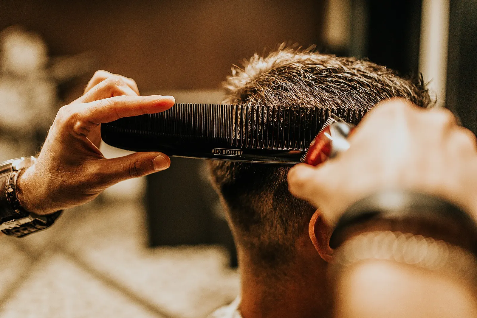 A barber combing and cutting a client’s hair