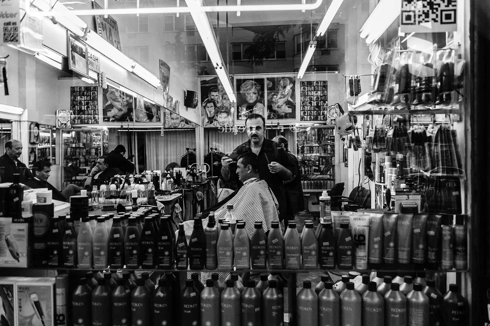 Inside a busy barbershop with products lining the walls